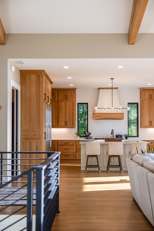 view of kitchen across from the bedroom wing through the flat bar railings and living room