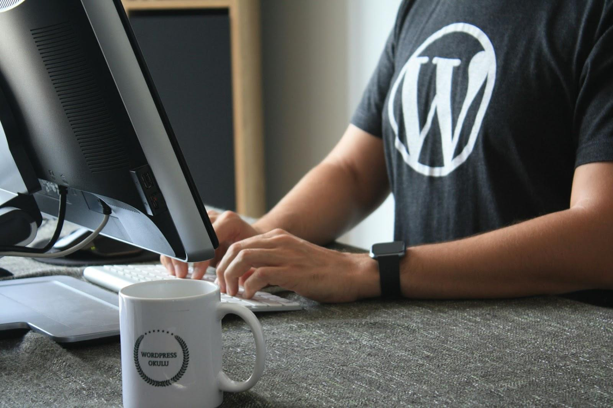 Man met wordpress-logo werkt op computer