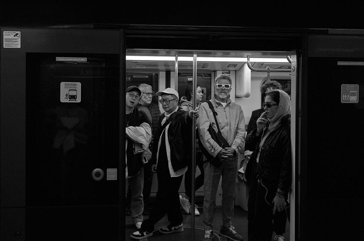 A group of diverse commuters standing in a Milan subway car, captured by photographer Sandeep Gajula