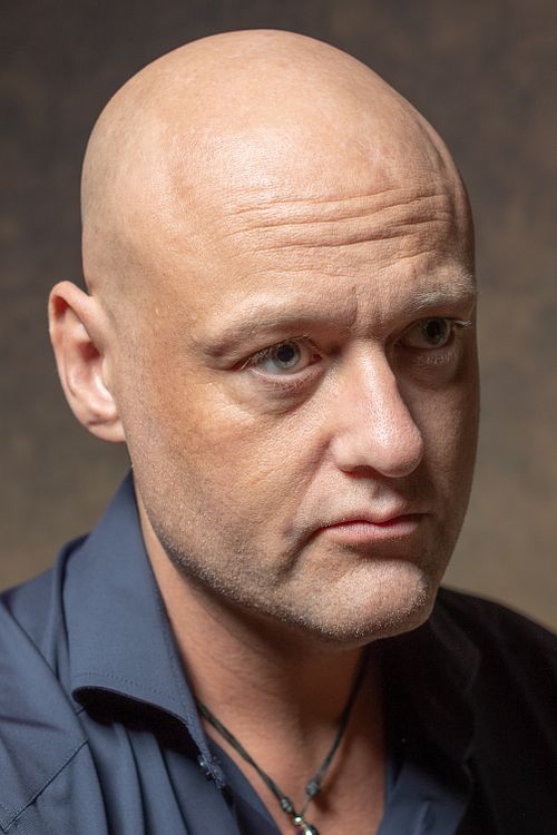 Man i mörk skjorta i varm tonad studio, ärlig och nära blick