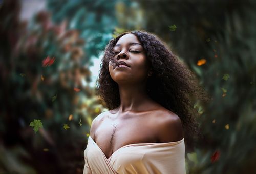 High school senior posing confidently outdoors in natural light.