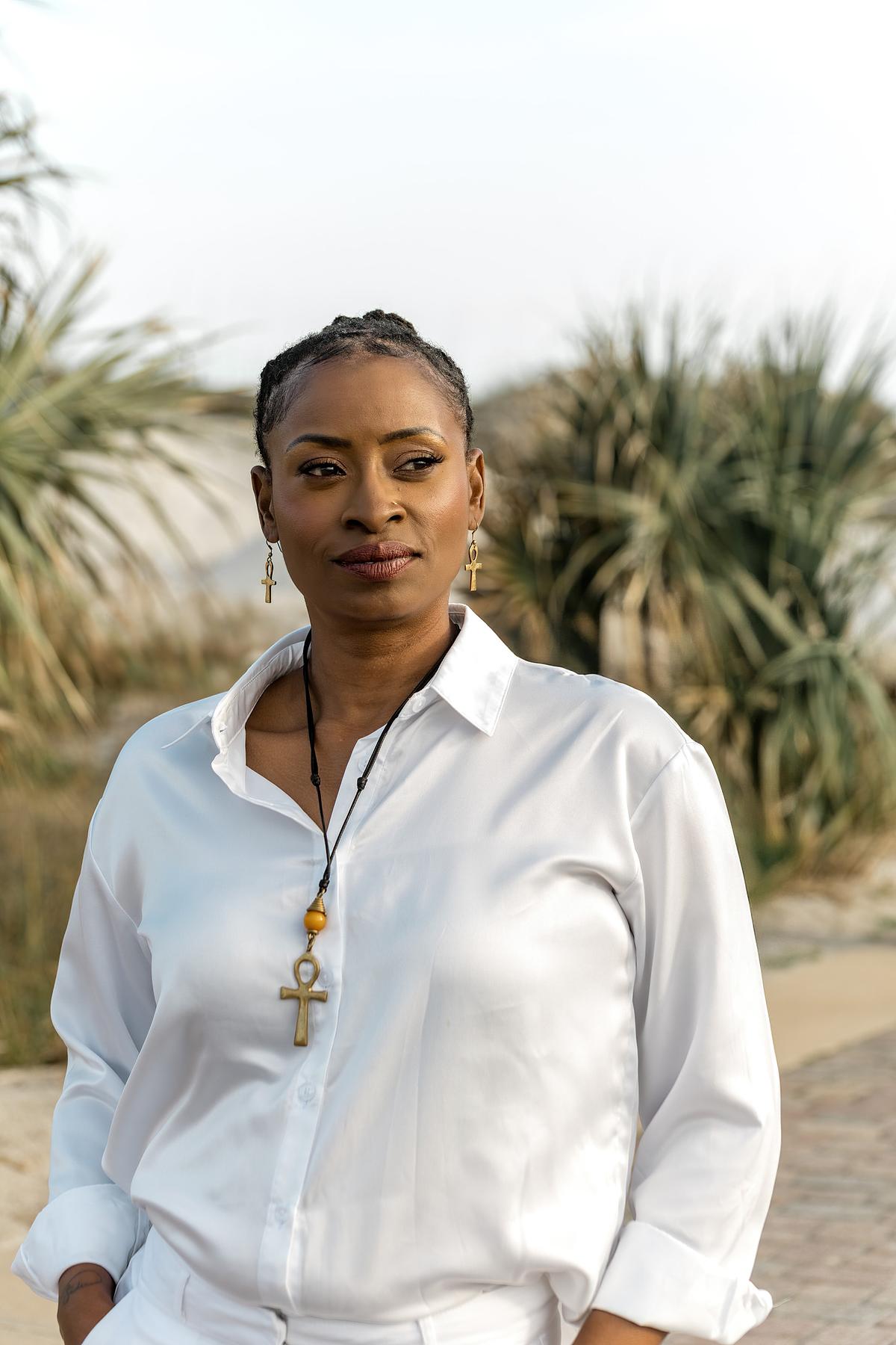 black woman who is a Reiki Master posing on an ocean front walkway during her branding session