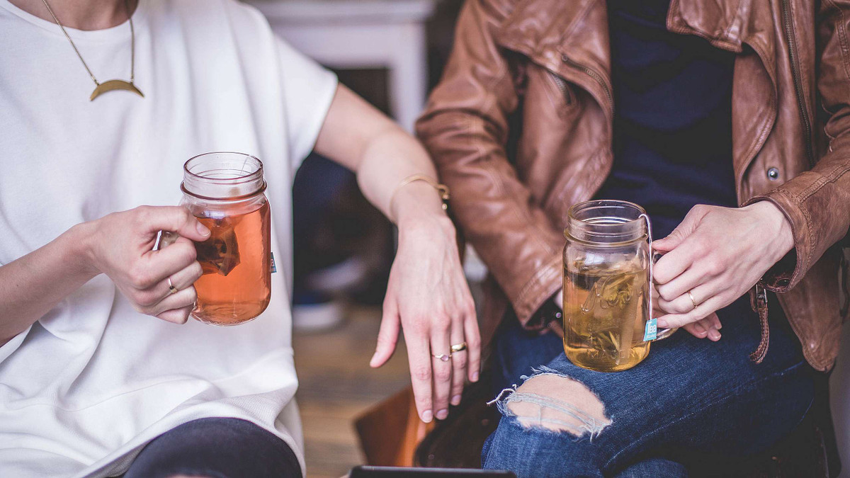 This image of two people holding cups of tea shows how filling the frame of an image creates a strong photo composition.
