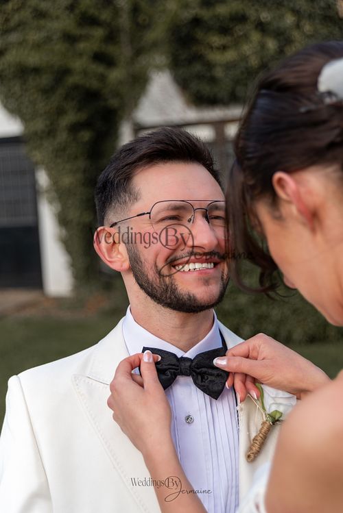 Bride adjusting groom’s bow tie at Sketchley Grange Hotel – captured by Weddings by Jermaine, Leicestershire wedding photographer