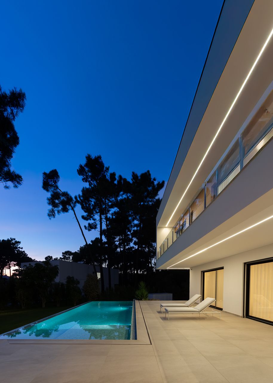 Fotografia de moradia contempor&acirc;nea na Herdade da Aroeira com piscina e ilumina&ccedil;&atilde;o noturna