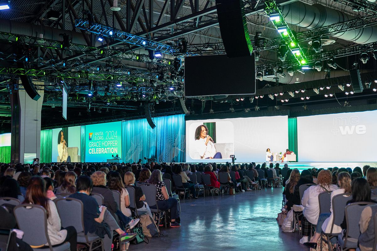 Corporate event photography capturing the 2024 Grace Hopper Celebration keynote session, showcasing large-scale conference production, stage lighting, and audience engagement in Philadelphia.