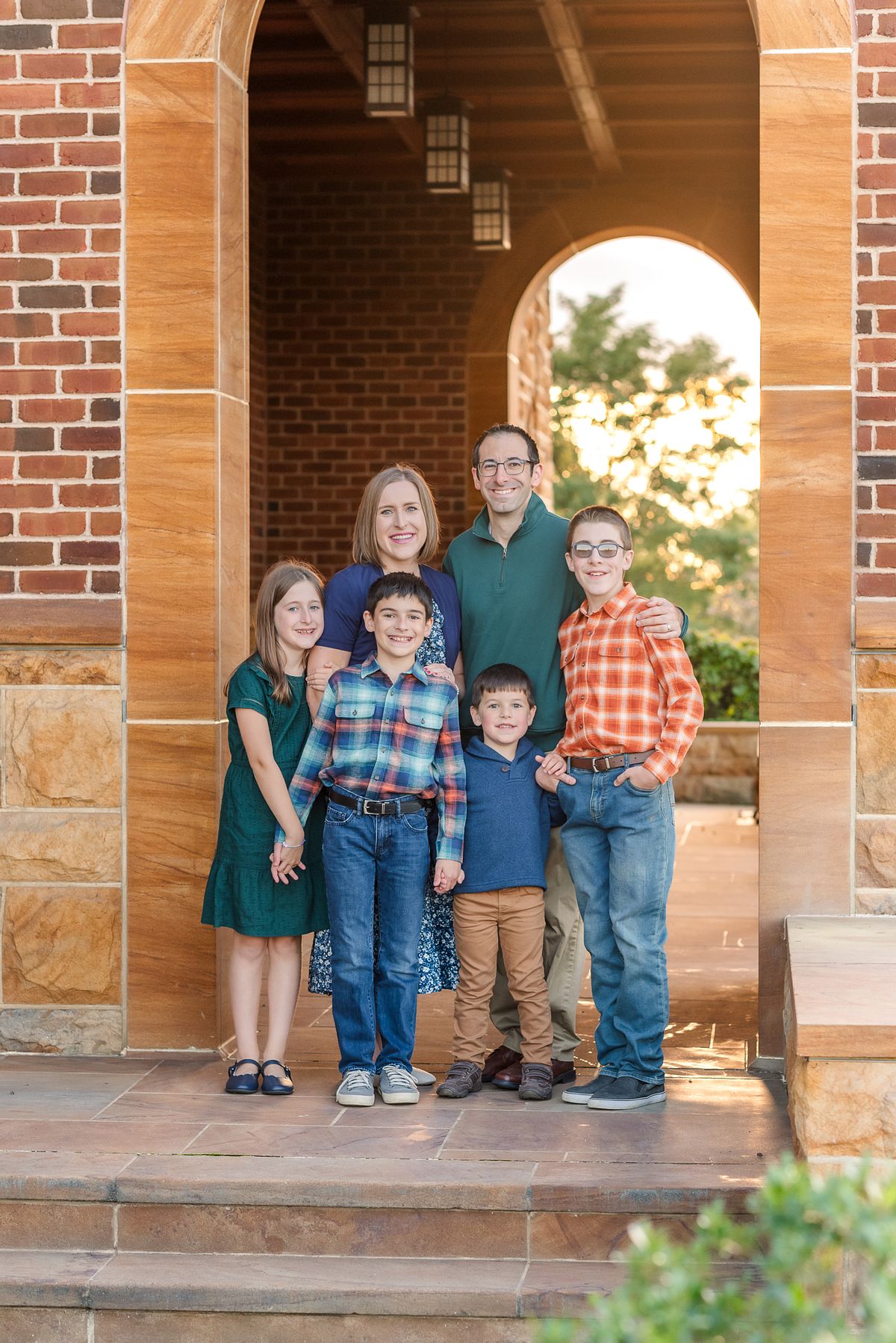 Family of six standing in archway of Wexford Saints John & Paul Church with a Cranberry Township, PA newborn photographer