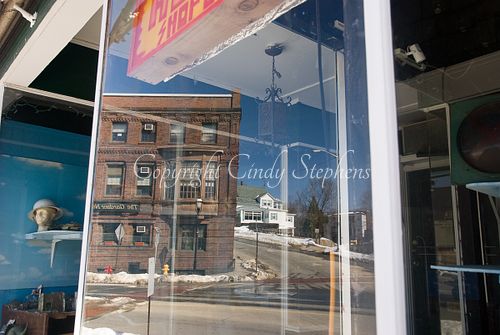 Gardner Massachusetts store window, helmet, snowy street, brick building.
