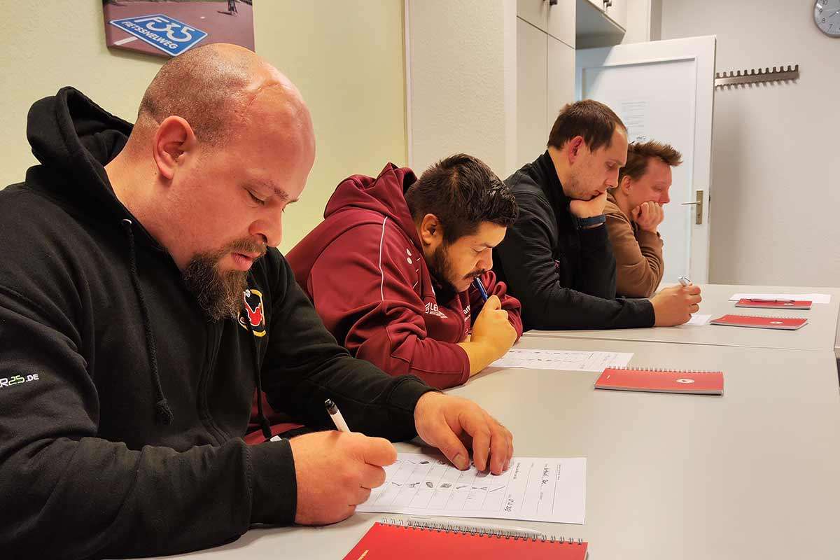 Abbildung zeigt: Spieler und Trainerin Inga beim Schulbank drücken