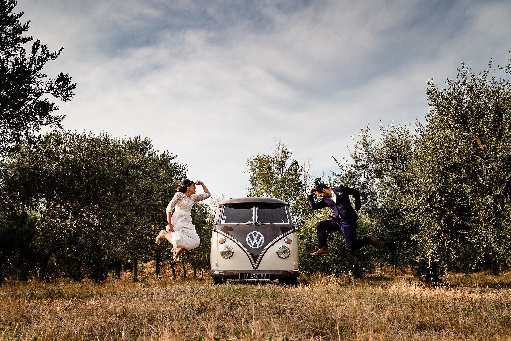 Portrait Couple de mari&eacute;s qui sautent devant leur Van Volkswagen captur&eacute; par S&eacute;bastien CLAVEL photographe de Mariage &agrave; Lyon et Gen&egrave;ve