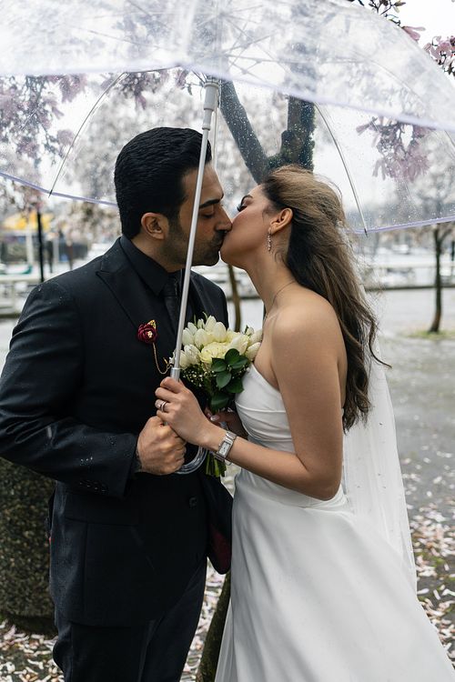 Bride and groom embracing during a rainy spring wedding photoshoot in Vancouver