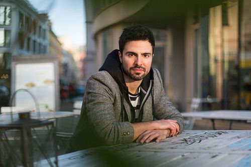 Toni Gojanovc in a gray jacket and striped sitting at the table.