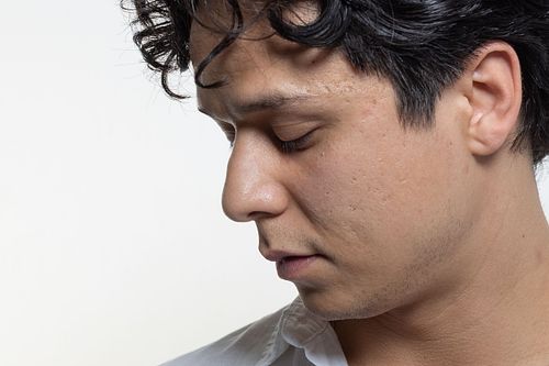 Man i profil mot vit bakgrund, ren och modern high-key-stil