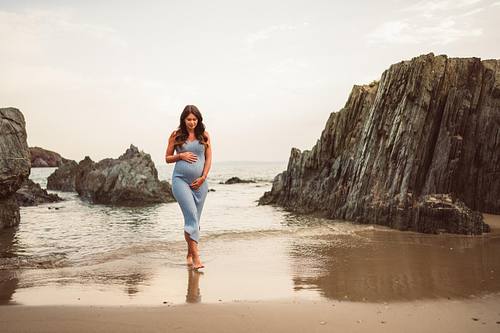 donna in gravidanza cammina nel bagnasciuga di Masua in Sardegna, Fotografo Gravidanza Cagliari Sud Sardegna