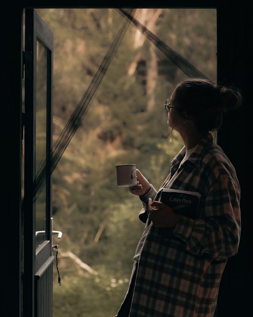 Quiet lifestyle moment by the window inside a forest cabin