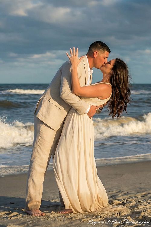 Couple kissing on a Florida beach at sunset during an engagement session by Legacy of Love Photography.