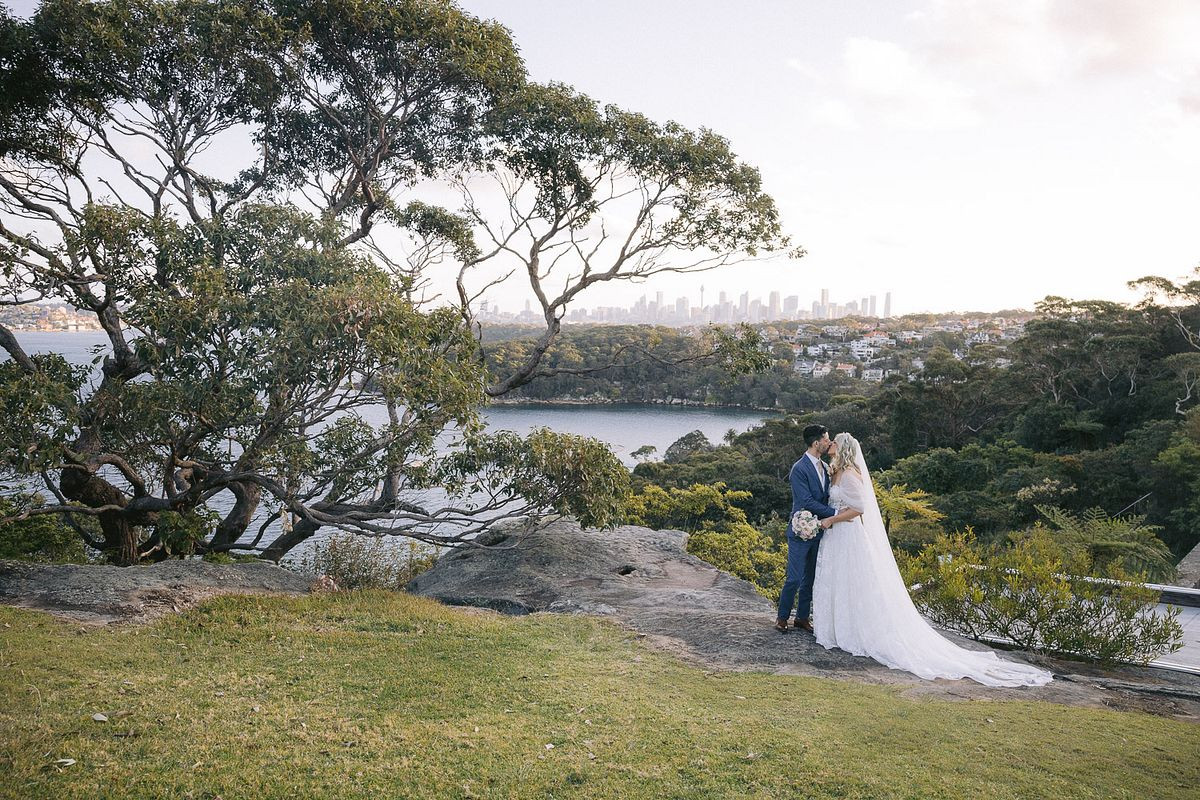 Bride and groom sharing a kiss with stunning backdrop at Georges Head Lookout Gunners Barracks Mosman.