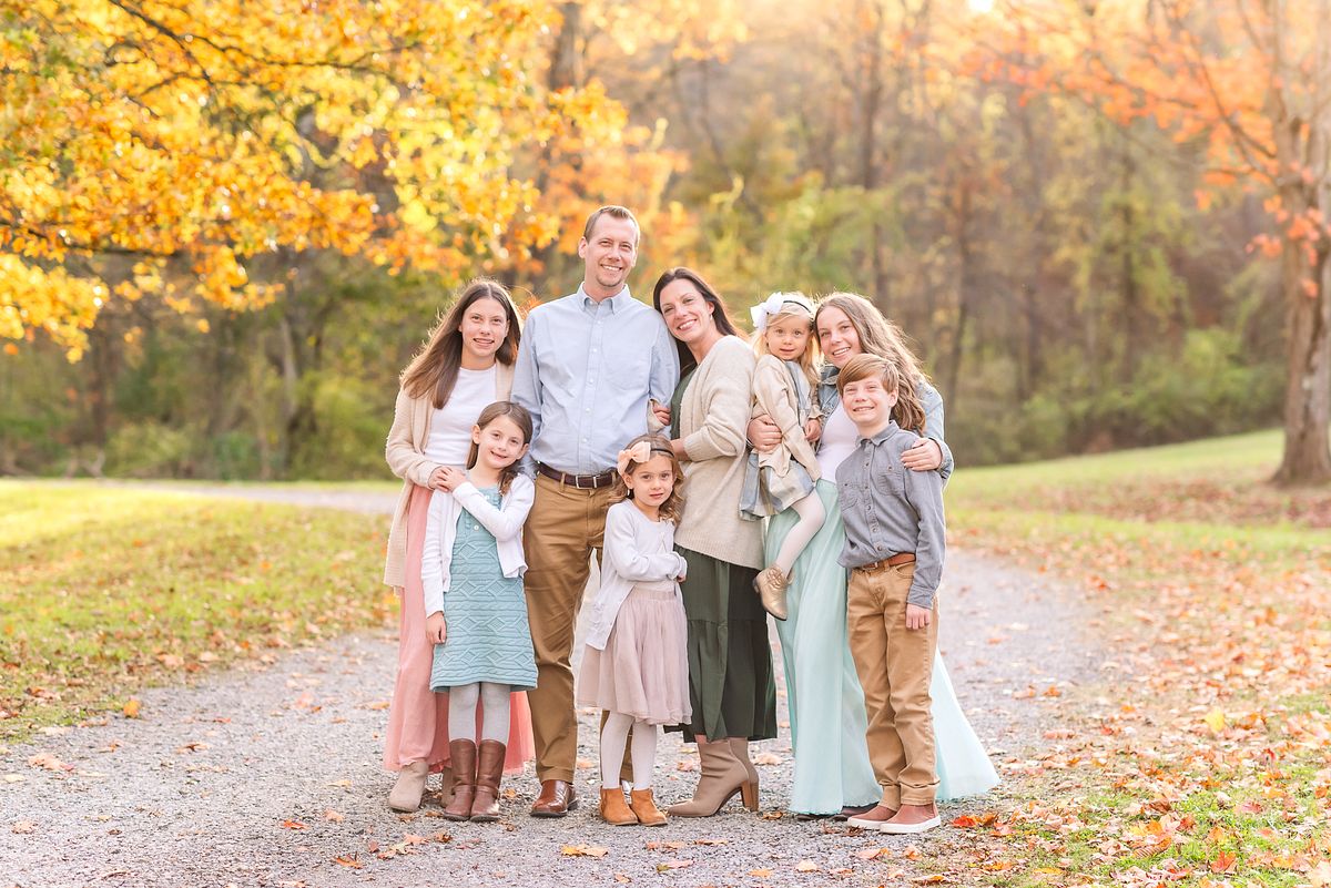 Family of eight on pathway, cuddled up together in fall golden hour light with Cranberry Township, PA newborn photographer