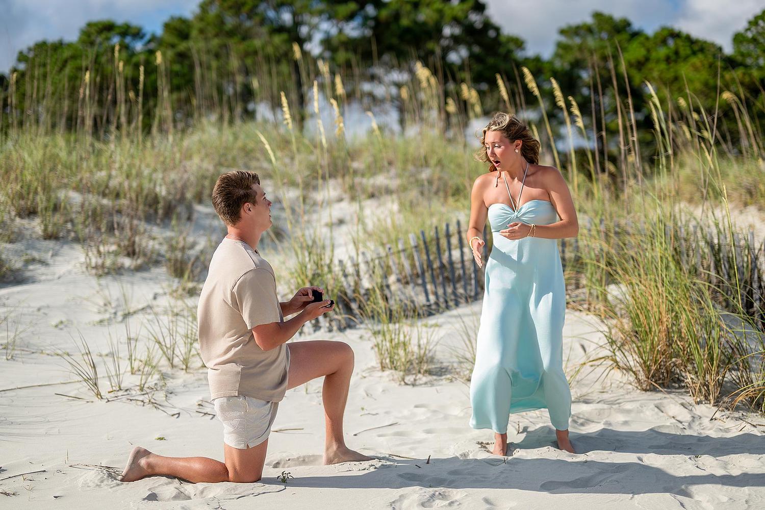 Man proposing on one knee to his partner on Seapines Beach, Hilton Head Island, South Carolina during a romantic engagement photography session.