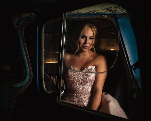 2020 Prince Albert Grad in a pink dress sitting in a vintage blue truck.