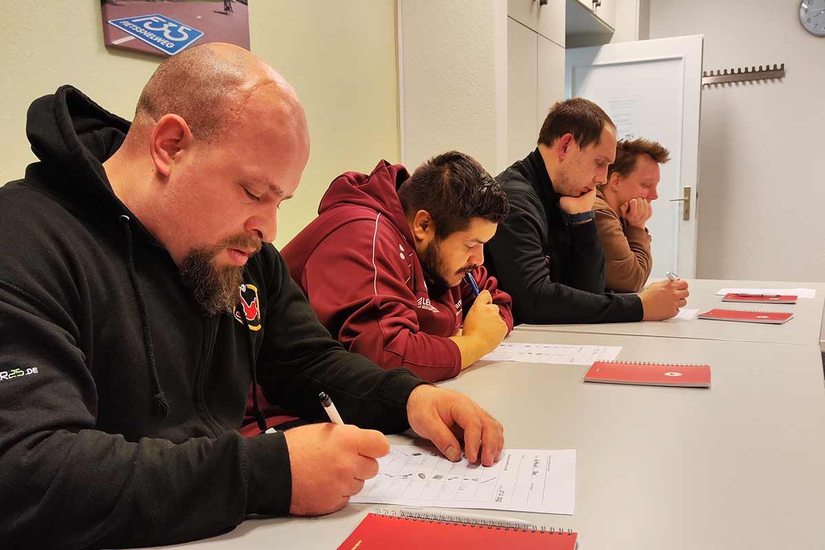 Abbildung zeigt: Spieler und Trainerin Inga beim Schulbank drücken