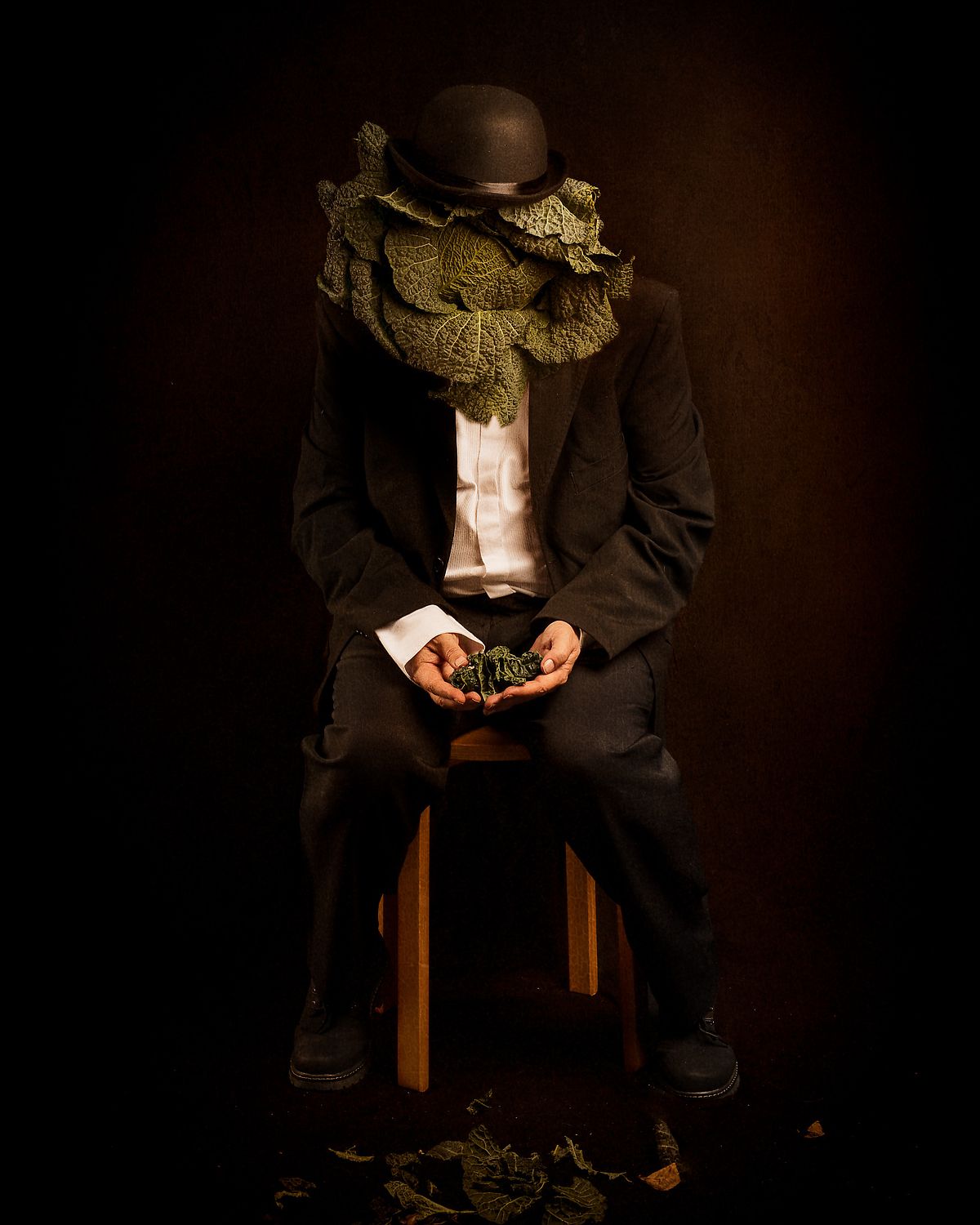 photo tarot Homme &agrave; T&ecirc;te de Chou, homme assis tenant des feuilles de chou, visage transform&eacute;, &eacute;vocation du temps qui passe