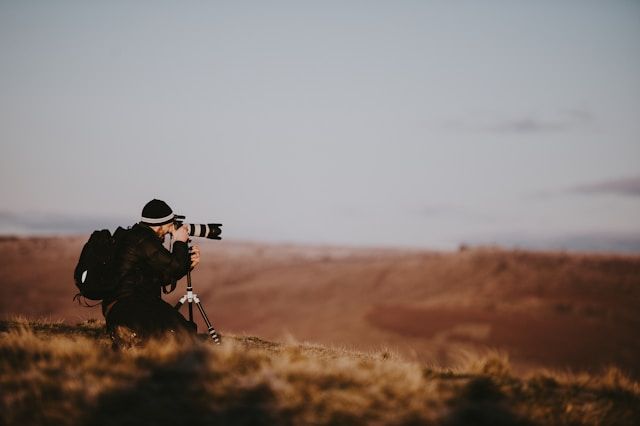 Imagem de um fotógrafo clicando em uma foto de paisagem