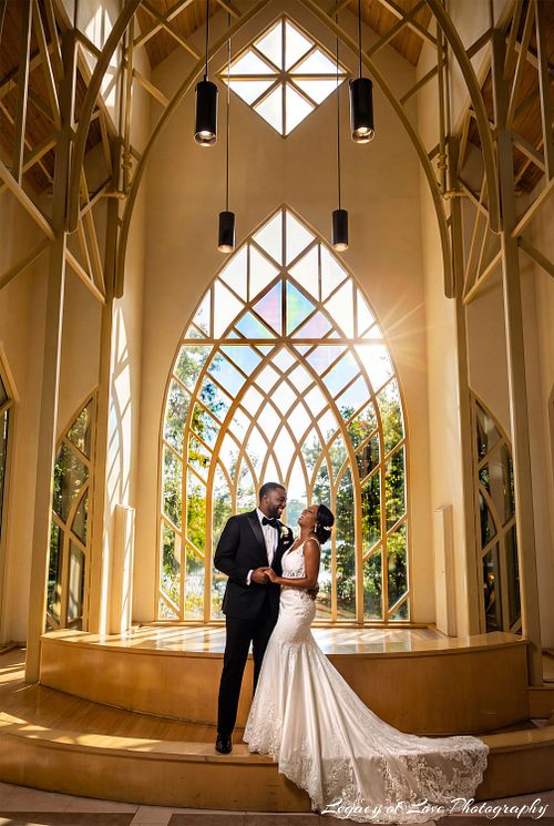A joyful bride and groom smiling and embracing inside the sun-drenched Baughman Center chapel in Gainesville, Florida.