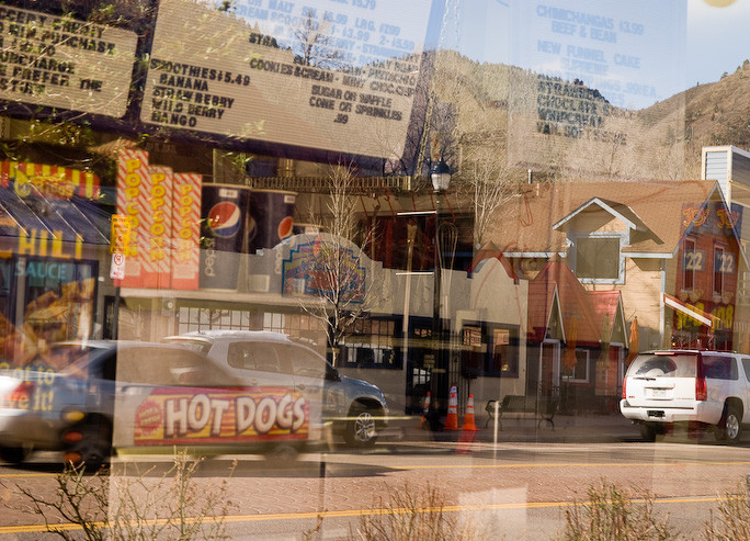 Reflection of restaurant menu and display against Colorado main street