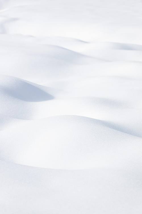 Ondulations de neige formant des vagues abstraites en hiver