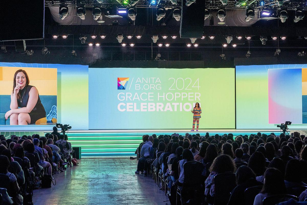 Keynote photography capturing a tech leader speaking on the main stage at the 2024 Grace Hopper Celebration in Philadelphia, emphasizing leadership presence, inclusion, and innovation within the tech community.