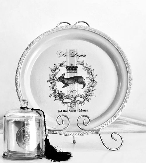 Vintage decorative plate with crown and rabbit design, paired with an elegant candle in a glass holder