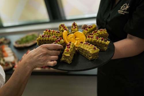Hands preparing and serving fresh café food in a working kitchen