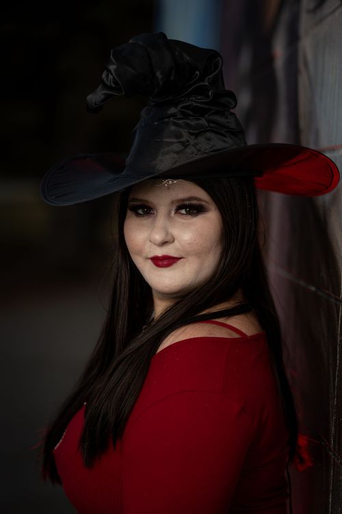 A witch in red poses for the camera.