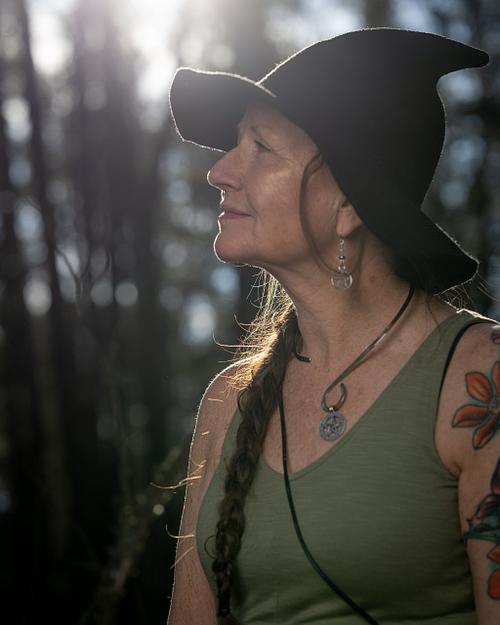 A crone witch enjoys the forest.