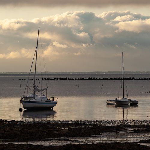 Deux voiliers sur mer calme.