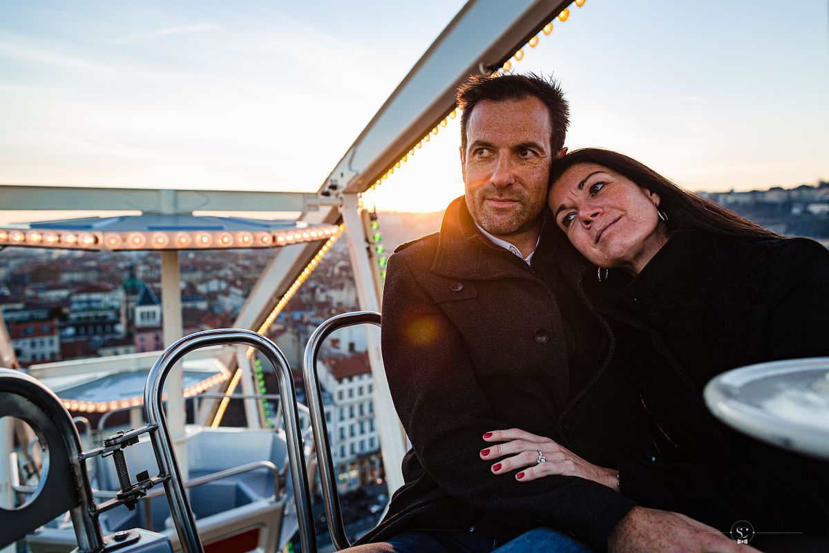 Tarif Photographe Mariage - Sebastien CLAVEL Photographe - Couple &eacute;treignant tendrement dans une grande roue, regardant le coucher de soleil sur Lyon