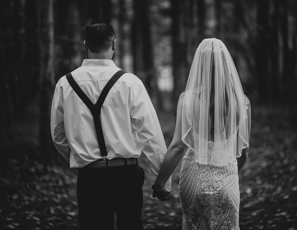 Black and white photo of the couple walking away after the wedding ceremony