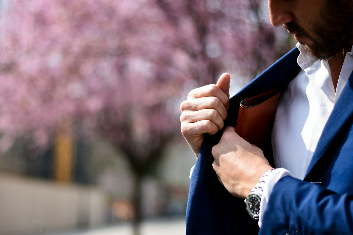 homme mettant son portefeuille dans la poche de son costume