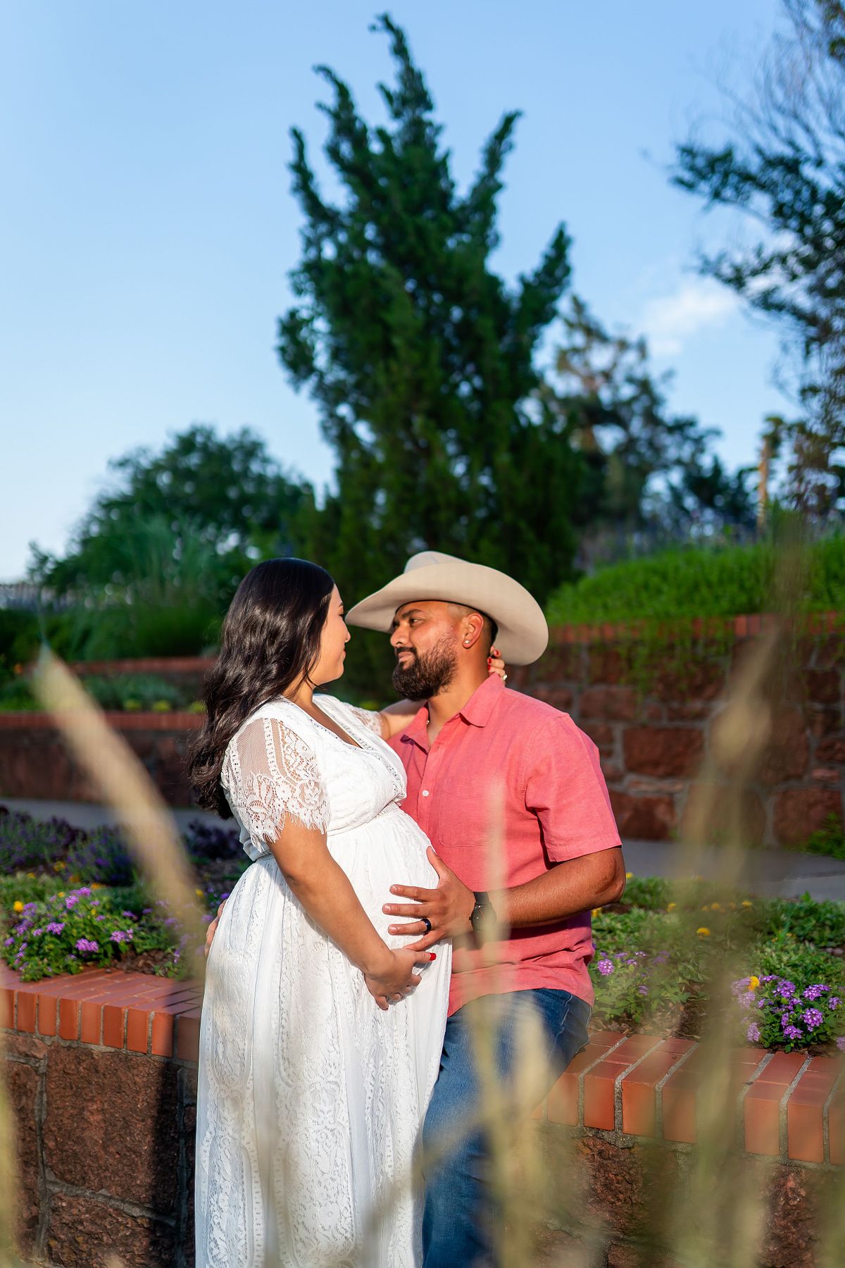 Pregnant woman posing in natural light with a flowing maternity gown.