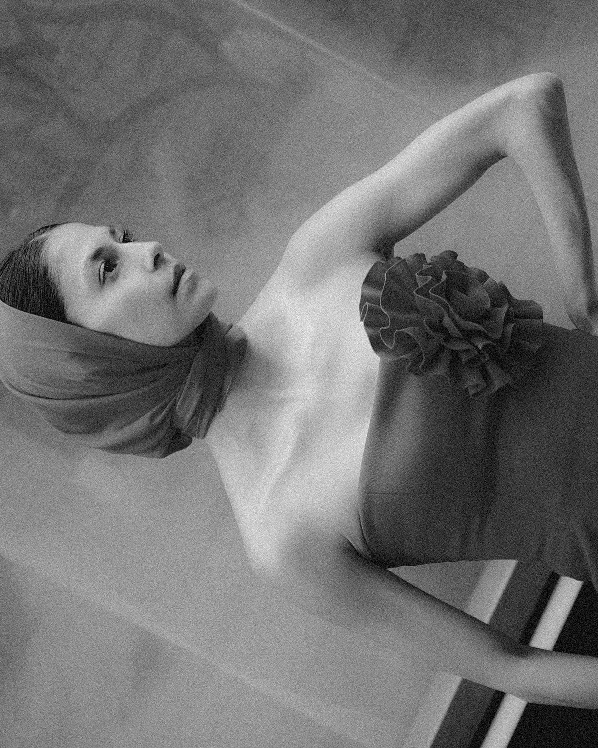 Black & white portrait of a female model wearing a top with statement flower inspired by Magda Butrym in the streets of Leipzig. Photographed by Filianna Karamanli.