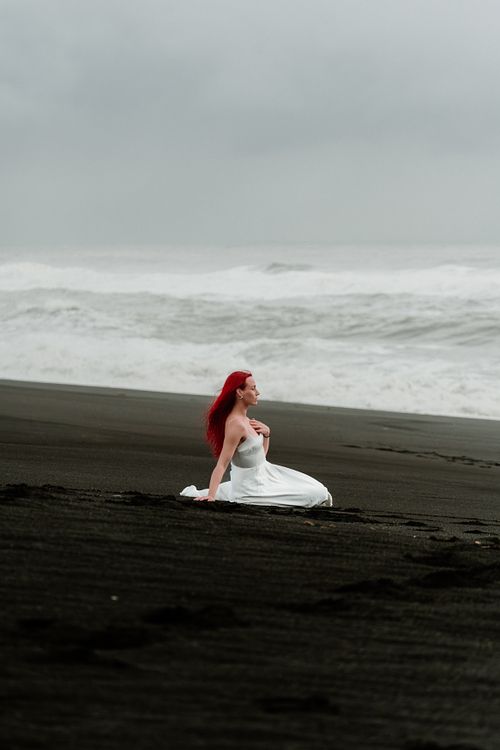 Minimalist white dress photoshoot at black sand beach in Iceland