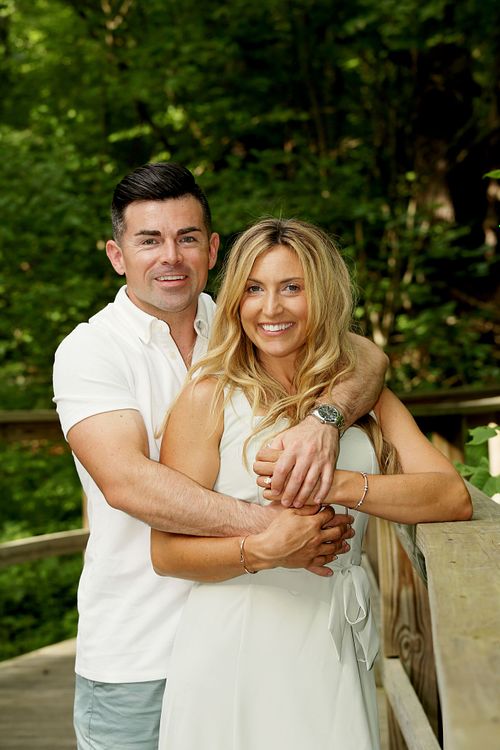 Soon to be married couple hugs in the park