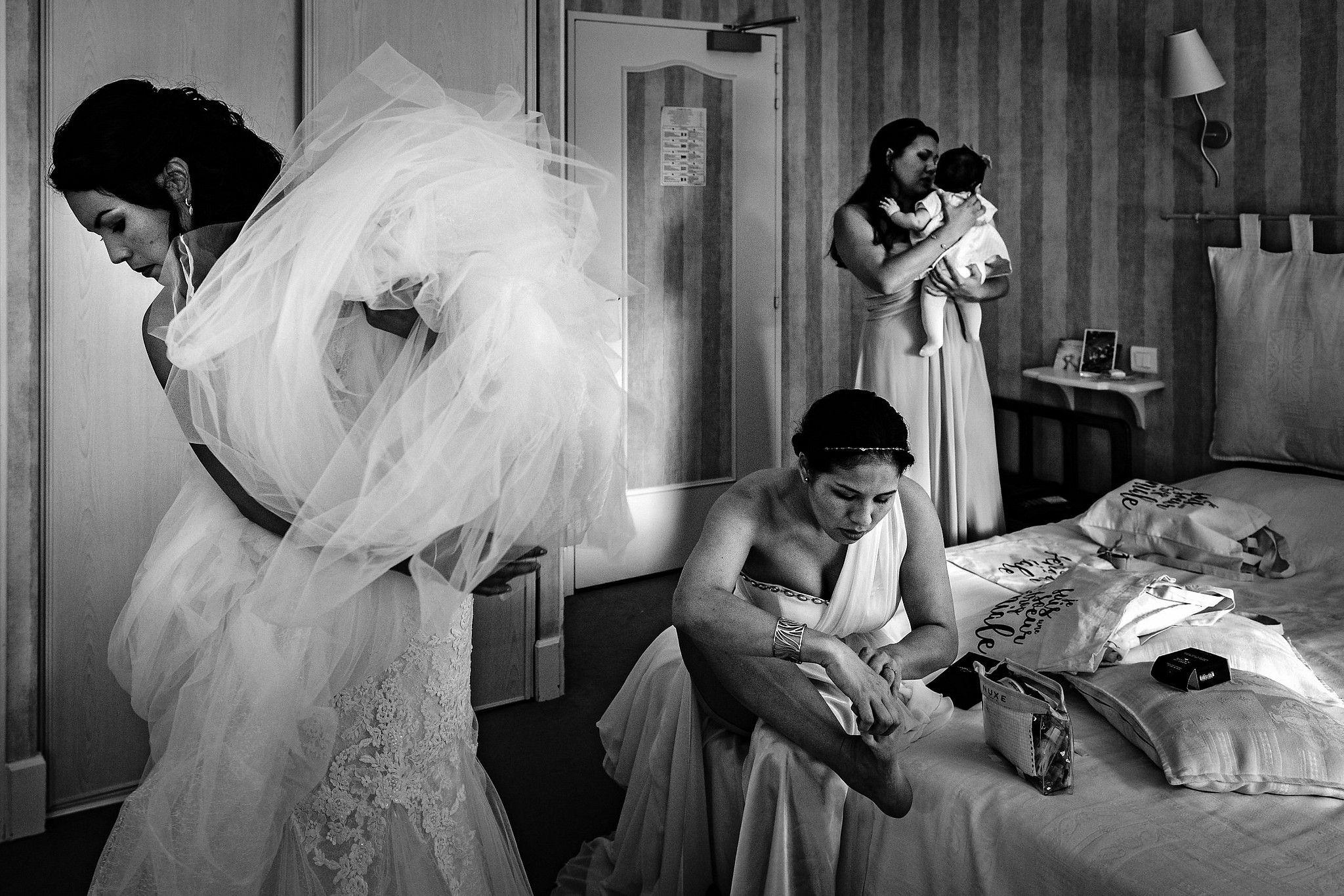 Mari&eacute;e qui se pr&eacute;pare dans sa chambre avec ses deux s&oelig;urs captur&eacute; par S&eacute;bastien CLAVEL photographe de Mariage &agrave; Lyon et Gen&egrave;ve