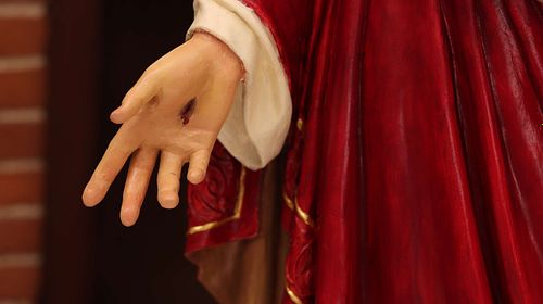 Restored hand on Sacred Heart of Jesus statue after paint.