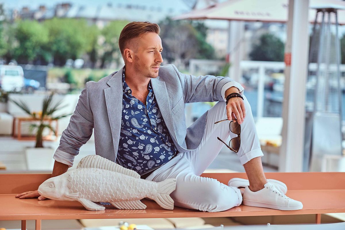 Successful man in modern elegant clothes at outdoor cafe against