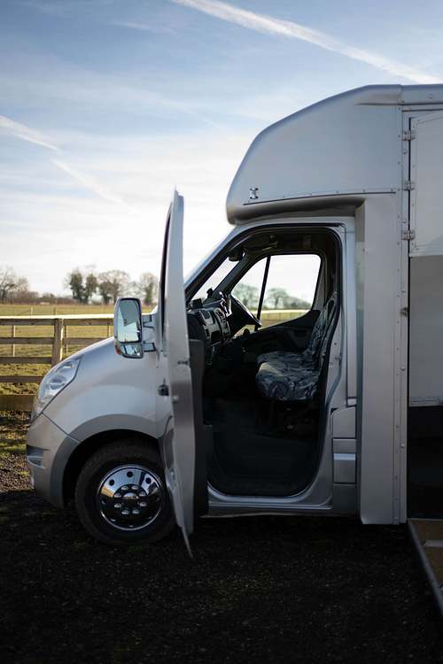 A horse box parked outdoors with the door open, set up for use as a mobile business